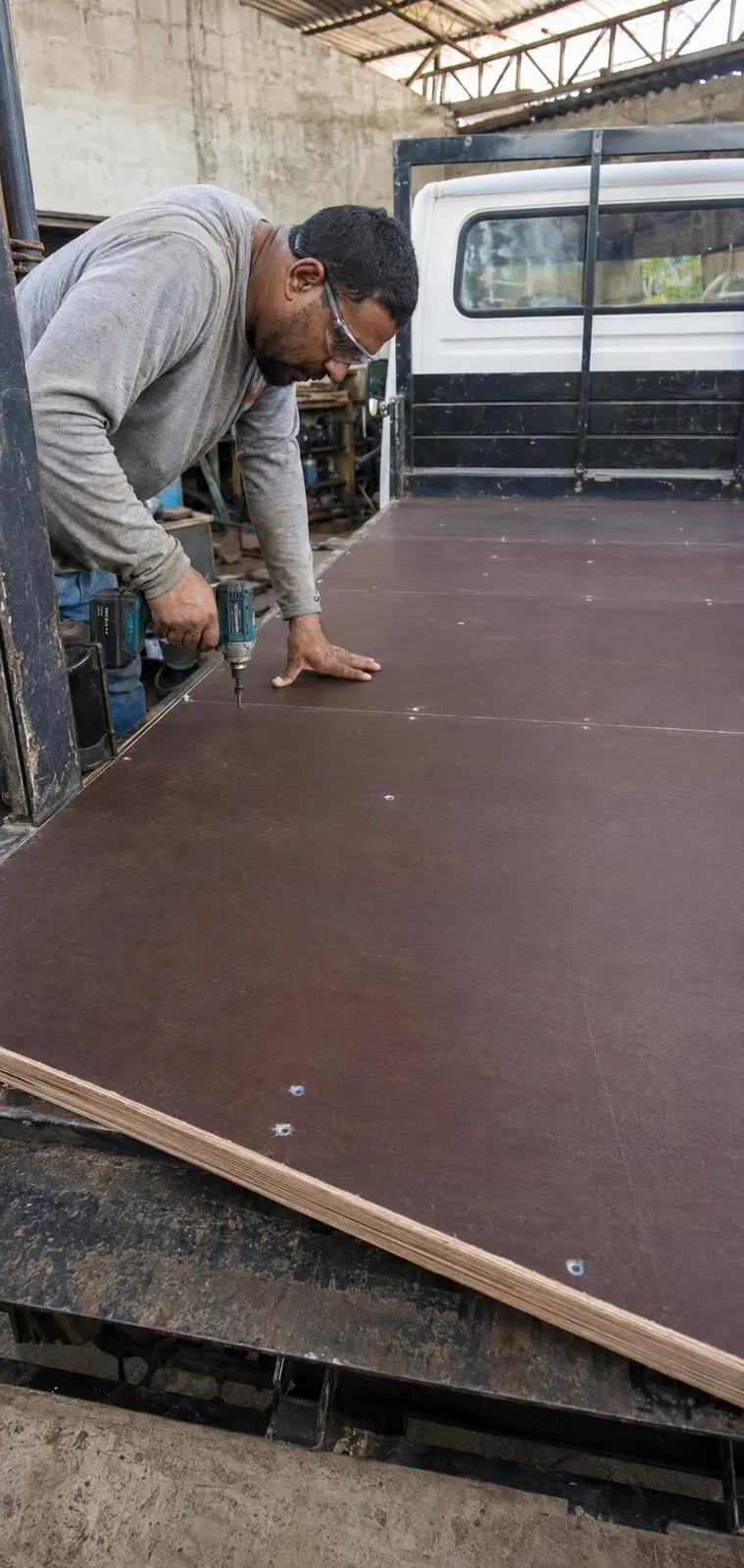 Profissional instalando piso de compensado em carroceria